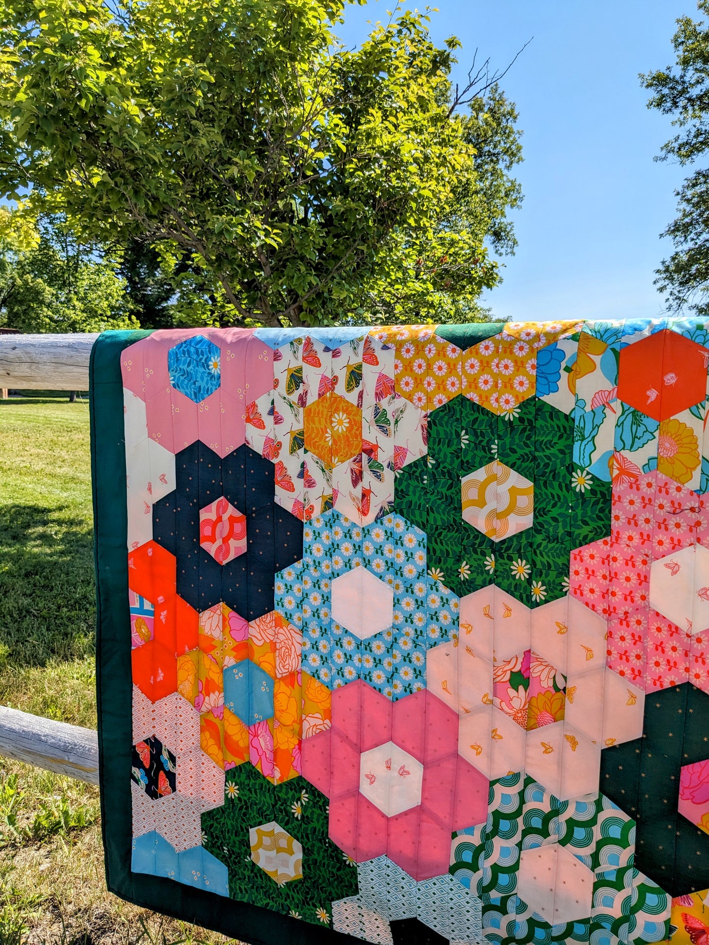 colorful hexagon flower quilt on fence