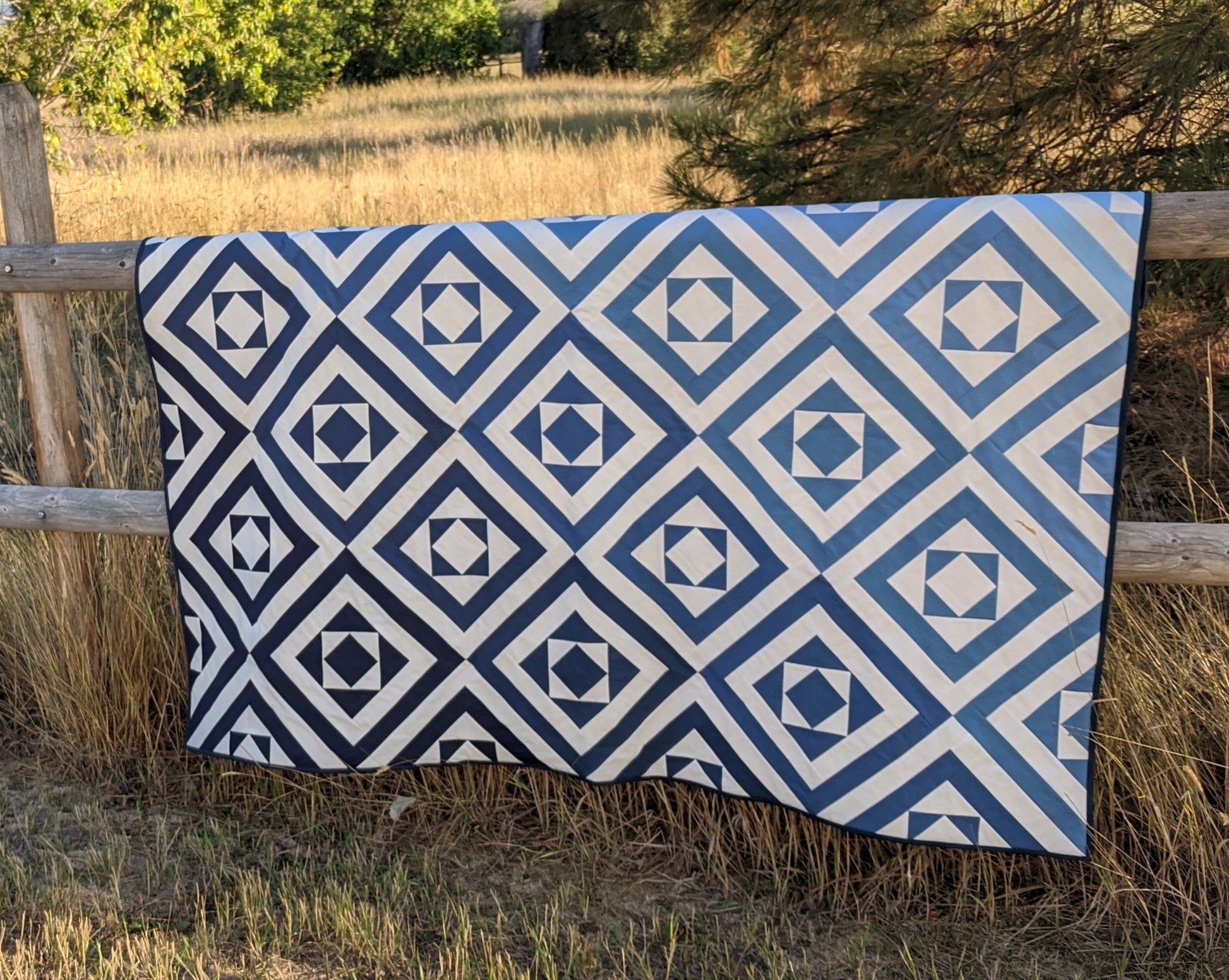 Modern ombre blue quilt on fence.