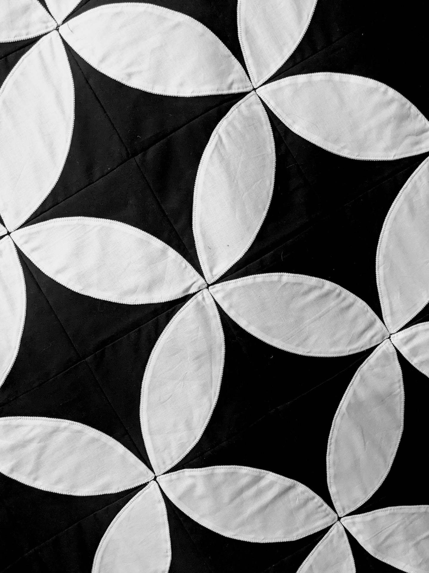 Close up of black and white appliqué quilt.